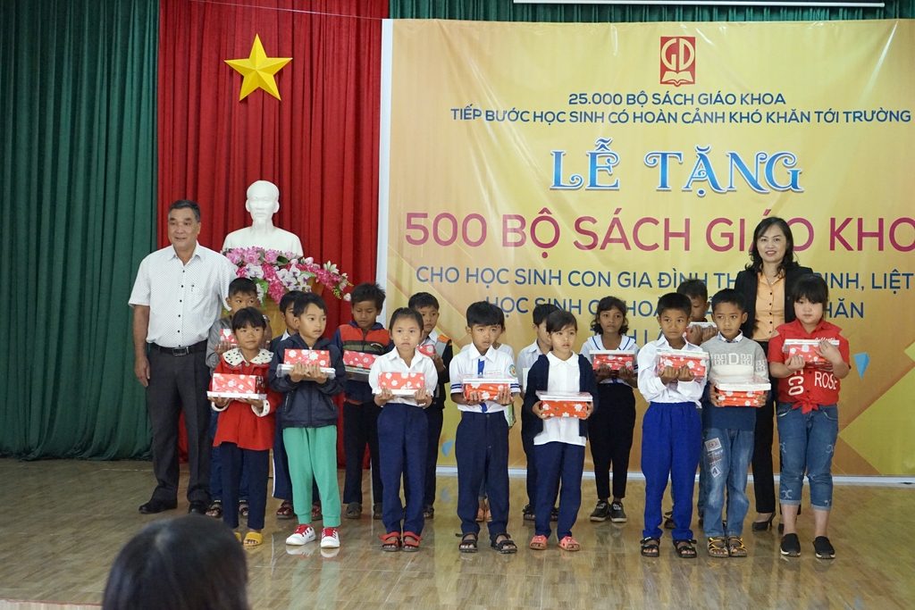 Ông Lê Đức - Trưởng phòng GD&ĐT huyện Bảo Lâm - và bà Nguyễn Thị Kim Phượng - GĐ Cty STBTH Lâm Đồng - trao tặng quà và SGK cho HS