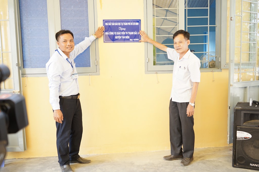 Ông Đỗ Thành Lâm - GĐ NXBGD tại TP. Hồ Chí Minh (phải) và thầy Phạm Quang Hải - Hiệu trưởng trường TH Thạnh Bắc A cùng gắn biển nhà công vụ